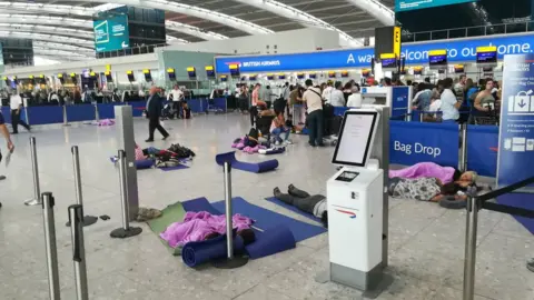 Anthony Rhodes People resting at Heathrow Airport