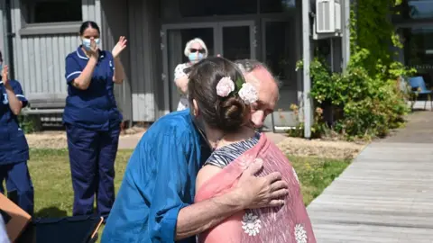 St Michael's Hospice Staff applaud as the couple embrace