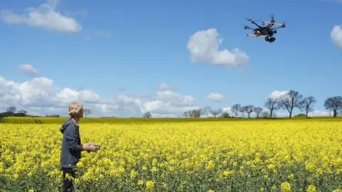 Getty Images Man flying a drone in a field