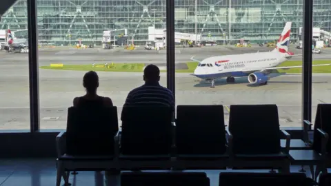 Empics Airline passengers at Heathrow Airport terminal Five