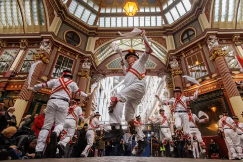 TOLGA AKMEN/EPA Members of Ewell St. Mary's Morris Men dancing team perform Morris dance at Leadenhall Market to celebrate St George's Day in London, Britain, 23 April 2024.