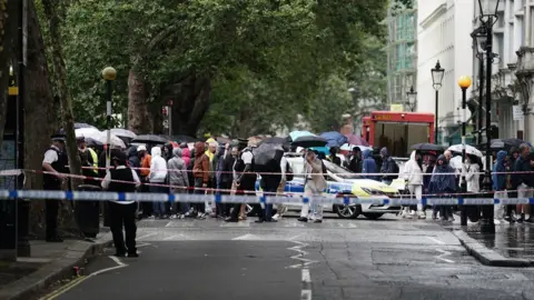 PA Media People stand behind a police cordon at the museum