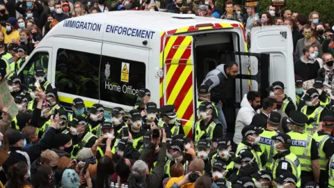 PA Media -Two men are released from the back of an Immigration Enforcement van accompanied by lawyer Aamer Anwar and Mohammad Asif, director of the Afghan Human Rights Foundation, in Kenmure Street, Glasgow