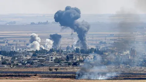 AFP Smoke rises from the Syrian town of Ras al-Ain on 14 October 2019