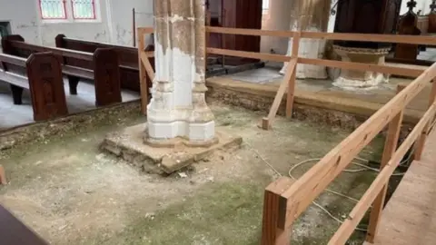 Part of floor missing around a stone column