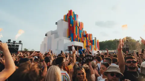 Giulia Spadafora Festival-goers dancing near a stage