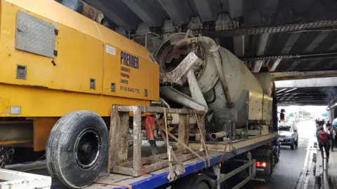 @JonRCandy / Twitter Lorry wedged under bridge