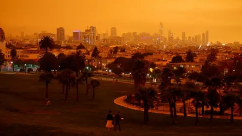 Reuters Downtown San Francisco is seen from Dolores Park under an orange sky