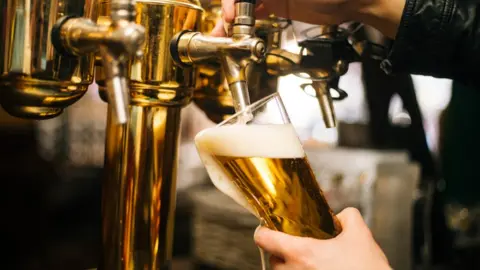 Getty Images A pub worker pouring beer