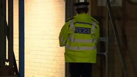 A police officer outside the building in Wood Green where the incident took place