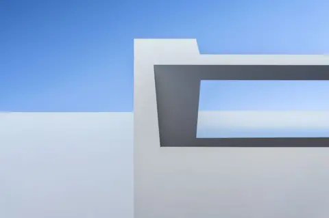 Marius Liutkevicius / APA18 A blue sky with the angular side of a grey building