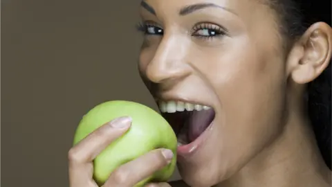 Getty Images Woman eating an apple