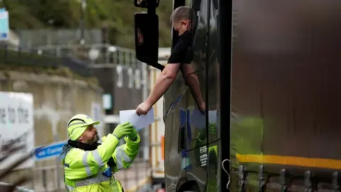 A lorry driver has a document checked