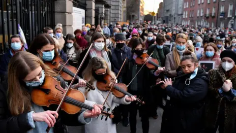 Reuters Musicians play during a memorial for Ashling Murphy outside Government buildings, in Dublin,