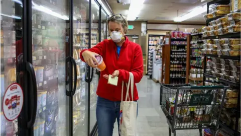 Getty Images Woman shops for groceries