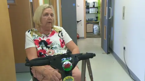 BBC Patient Euryl James sitting on a mobility scooter in a hospital corridor