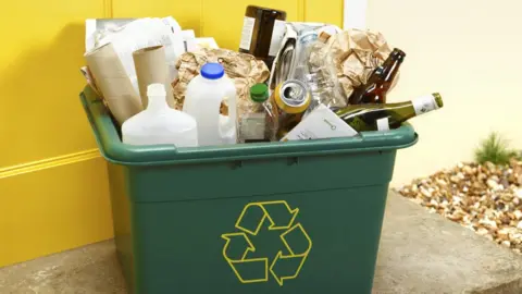 Getty Images Full household recycling bin - glass bottles, milk bottles and paper wrapping visible