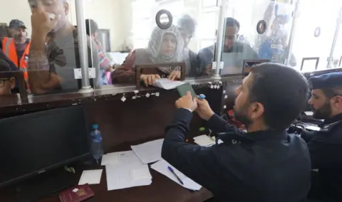 Getty Images People showing their passports at the Rafah crossing