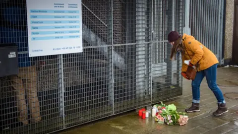 Getty Images People put down flowers in front of the building where the attack happened