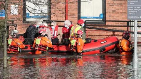 Reuters Firefighters transporting people in dinghy