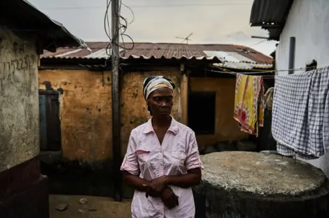 Hugh Kinsella Cunningham Eva Nah pictured outside her house in West Point, Monrovia, Liberia.