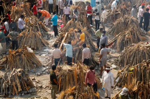 Adnan Abidi / Reuters People prepare funeral pyres for a mass cremation in New Delhi, India