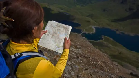 Getty Images Woman reading a map in Snowdonia