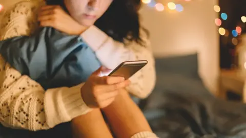 Getty Images Young girl looking at her phone