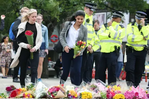 Isabel Infantes People lay flowers near London Bridge station following Saturday's terror attack.