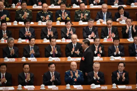 Getty Images Delegates applaud as China's President Xi Jinping (C) walks past before he delivers a speech during the closing session of the National People's Congress at the Great Hall of the People in Beijing on March 20, 2018.