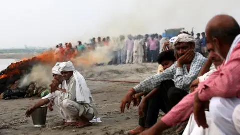 EPA People cremate the bodies of the victims near the site where a riverboat capsized carrying 60 people in Baghpat, Uttar Pradesh, India, 14 September 2017.