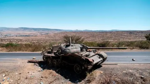 AFP via Getty Images A damaged tank stands on a road north of Mekele, the capital of Tigray on February 26, 2021
