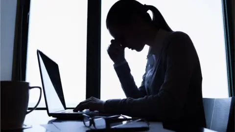 Getty Images Stressed worker at desk