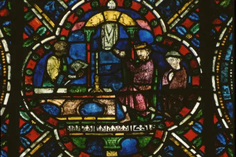 Getty Images A stained glass window in Canterbury cathedral depicts Henry II doing penance at the tomb of St Thomas