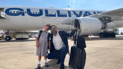 Madison, from Milton Keynes, and her dad Mark Baker in front of a plane at Luton Airport