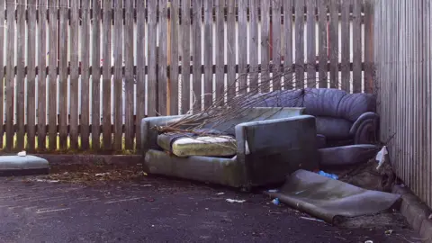 Getty Images Sofas abandoned against a fence