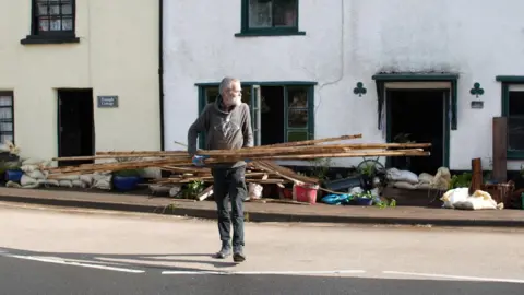 Man carrying wood damaged in a flood