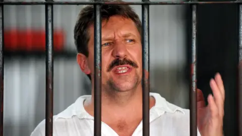 Getty Images Russian arms dealer Viktor Bout speaks to the press from behind his cell bars of the criminal court detention centre in Bangkok in April 2008