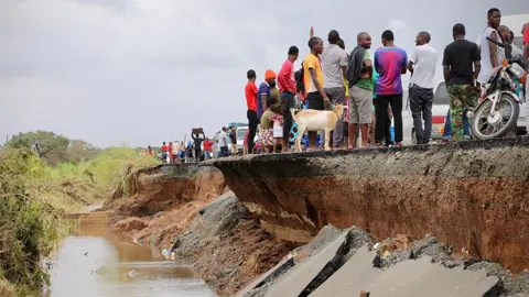 ADRIEN BARBIER People gather on a destroyed section of road