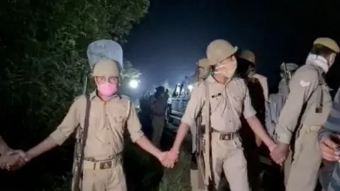 Abhishek Mathur / BBC Policemen form a human chain