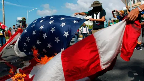 AFP Protesters burn a U.S. flag during a protest against the referendum for Puerto Rico political status in San Juan, on June 11, 2017