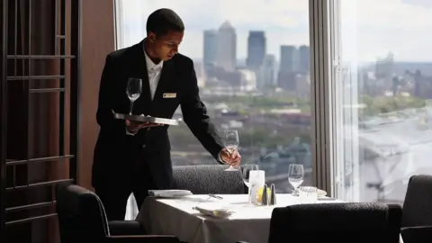 Getty Images A waiter prepares a table