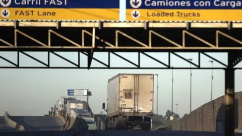 Trucks drive to cross the border with the United States at Otay Mesa Commercial Port of Entry in Tijuana, Mexico in 2018