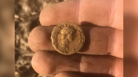 George Ridgway Gold coin being held in a hand