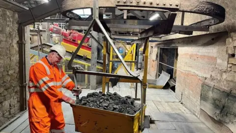 Man with bucket of clay
