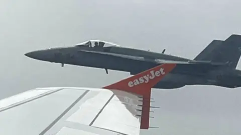 Marcos Torre/Reuters Uno de los dos cazas F18 españoles vistos a través de la ventanilla de un vuelo de EasyJet de Londres a Menorca