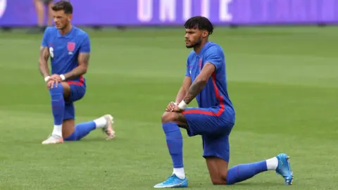 The FA via Getty Images Tyrone Mings takes the knee