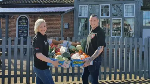 Amanda Allen Trina Lake and Bradley Richards with boxes of fruit and vegetables