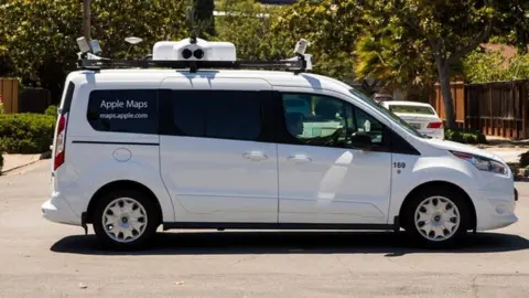 Apple A picture of a white van with camera equipment on the roof and 'Apple Maps' written on it