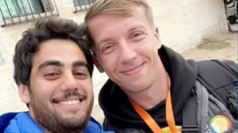 Palestinian World Central Kitchen aid worker Saif Abu Taha and Polish worker Damian Sobol pose for a selfie